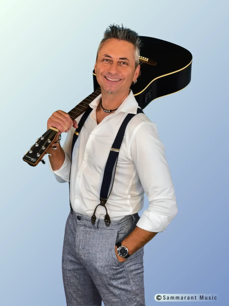 Andy Amberg mit Gitarre über der Schulter